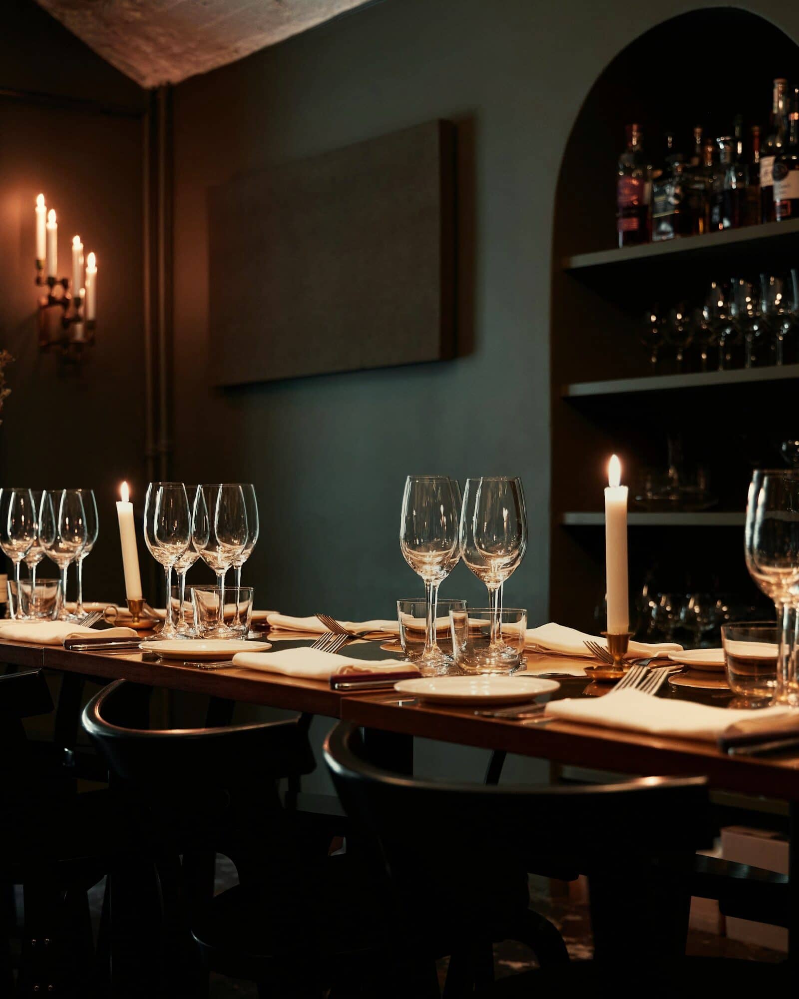 A private dining room, the table set with candles and glasses before guests arrive